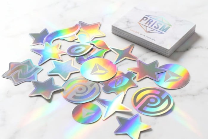 Guía de pegatinas holográficas personalizadas que muestra efectos de difracción arcoíris en película de poliéster metalizado