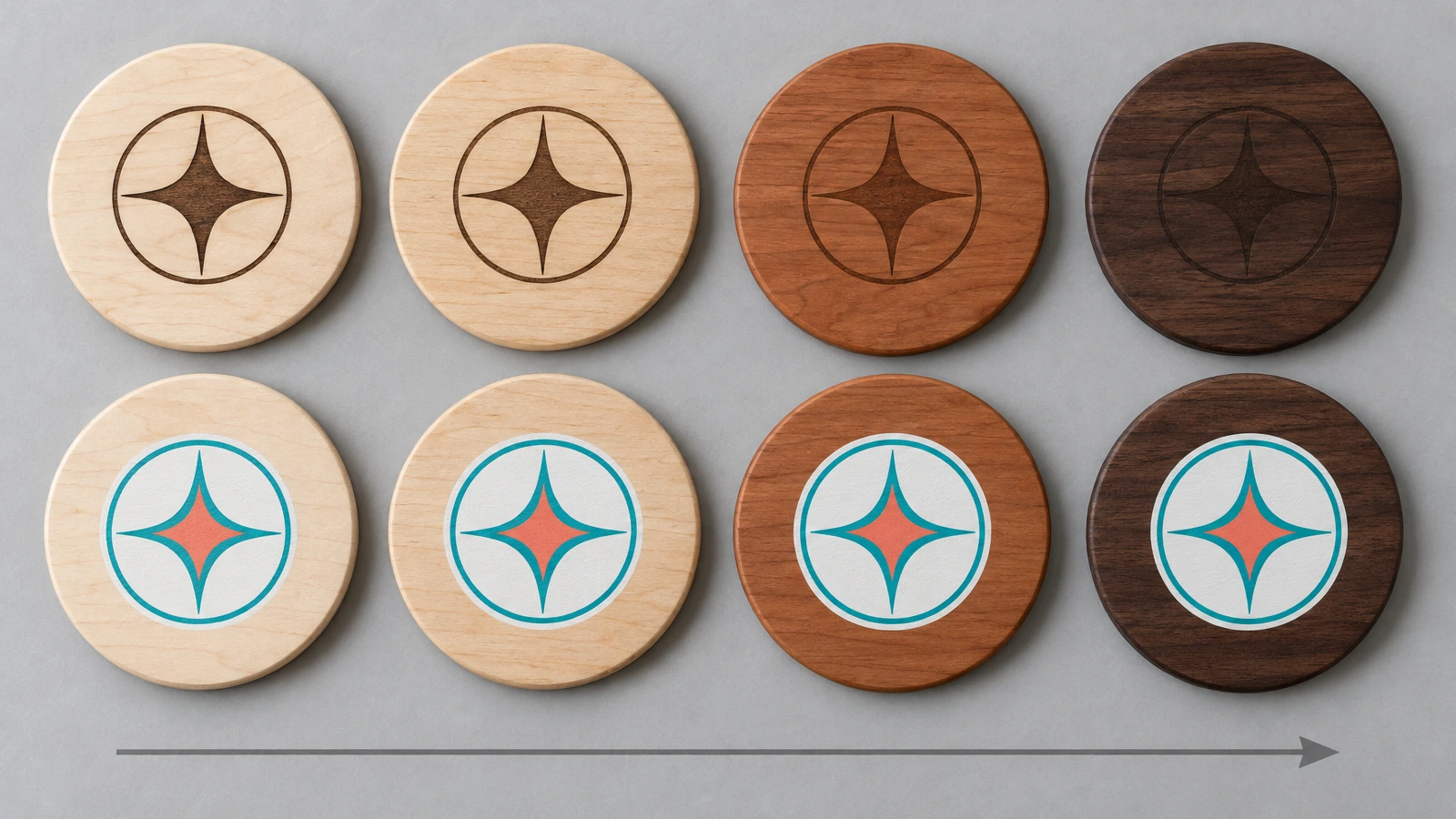 Hilera de posavasos redondos de madera, del arce claro al nogal oscuro, todos decorados con el mismo emblema abstracto, que muestra cómo el contraste del grabado se atenúa en la madera más oscura mientras el color impreso sigue visible