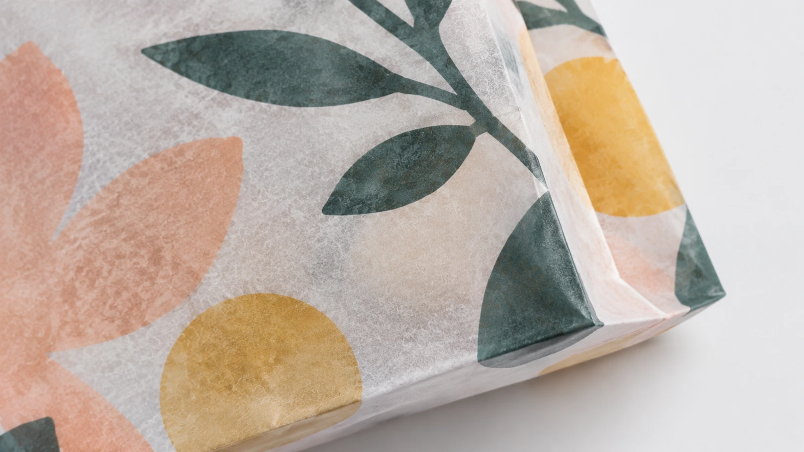 Textura del papel impreso y pliegue inferior Primer plano del papel estampado con motivos florales y de la esquina inferior doblada