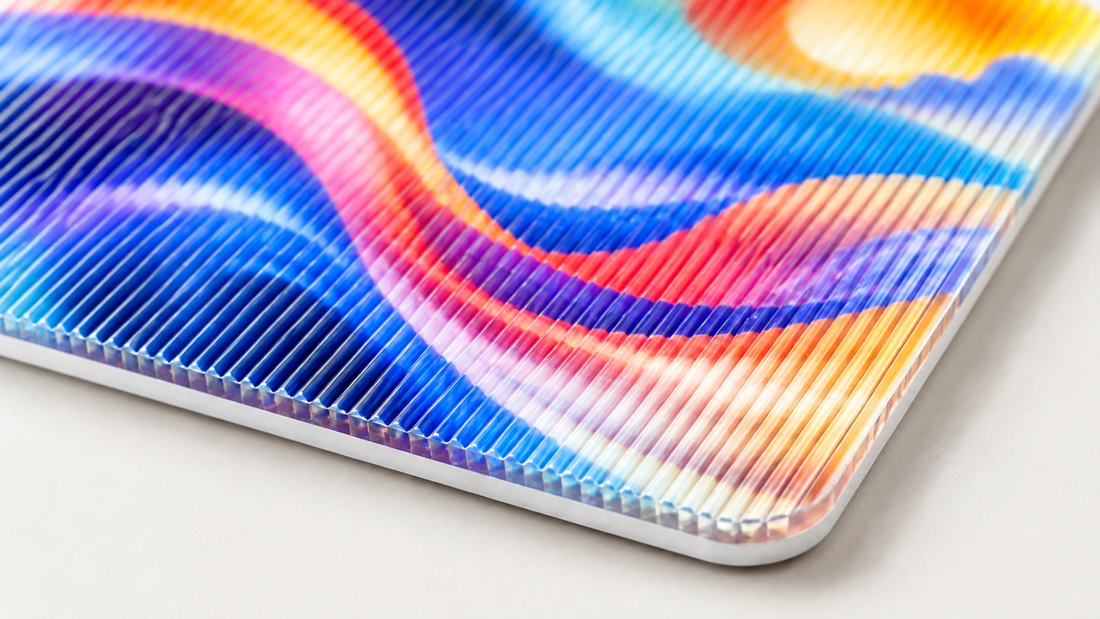 Detalle de estrías y esquina lenticulares Primer plano de una muestra lenticular de colores que muestra estrías paralelas y una esquina redondeada
