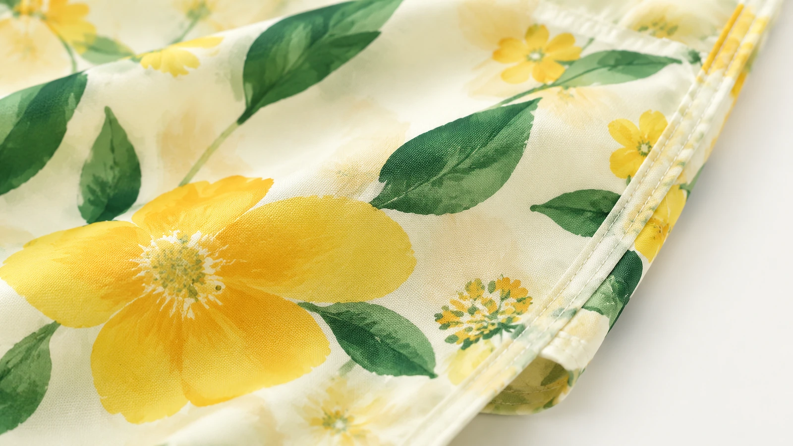 Primer plano de tela floral amarilla y borde cosido de un bolso