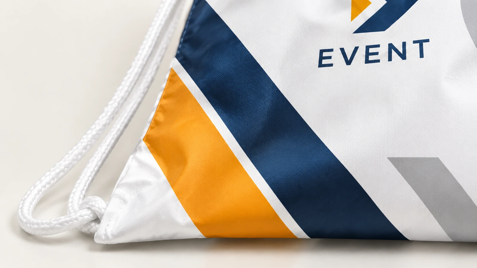 Primer plano del cordón blanco, del anclaje de la esquina y de la superficie impresa en azul y naranja de la bolsa