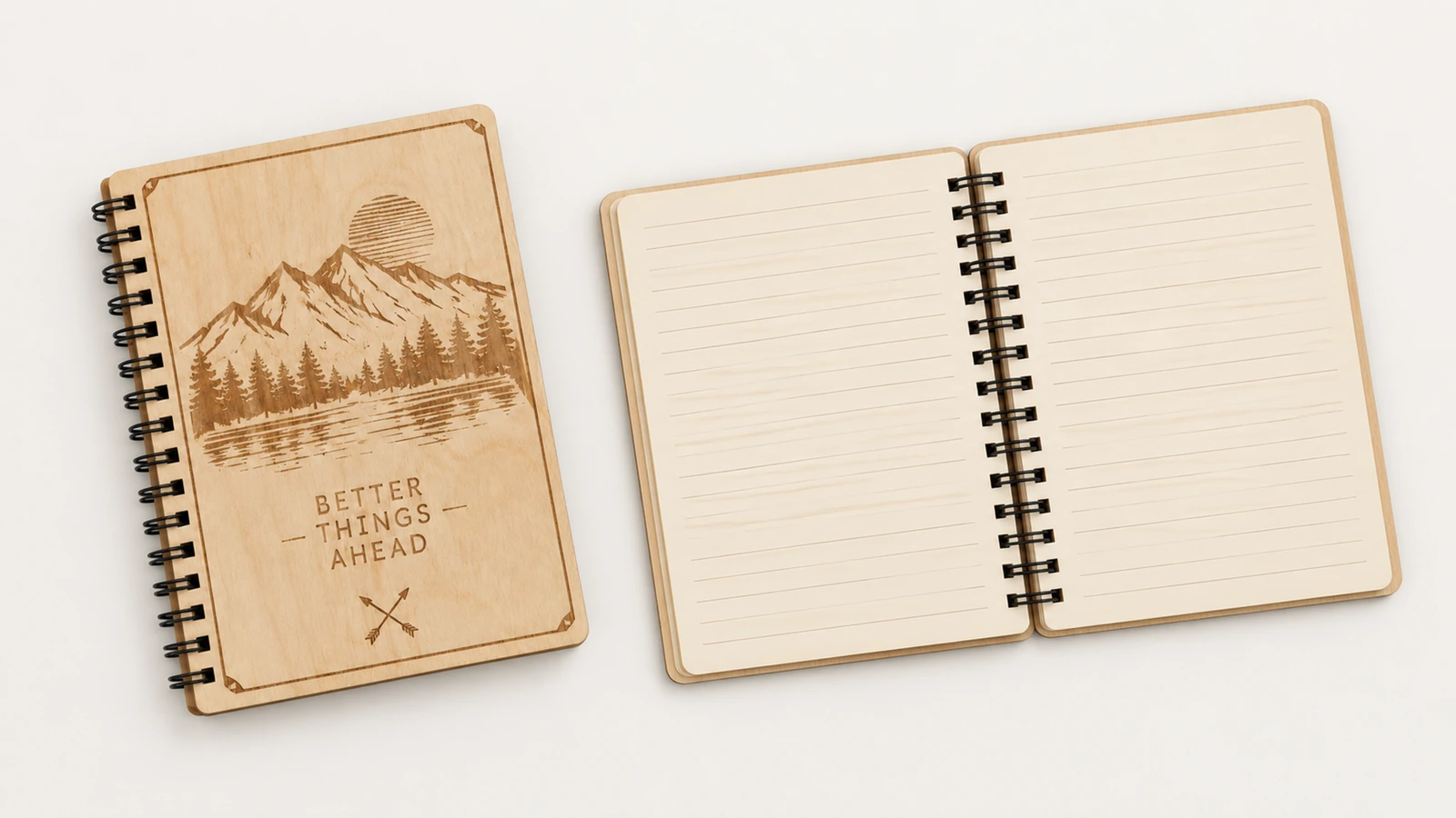 Cuaderno cerrado de contrachapado con diseño de montaña junto a un cuaderno abierto con páginas rayadas