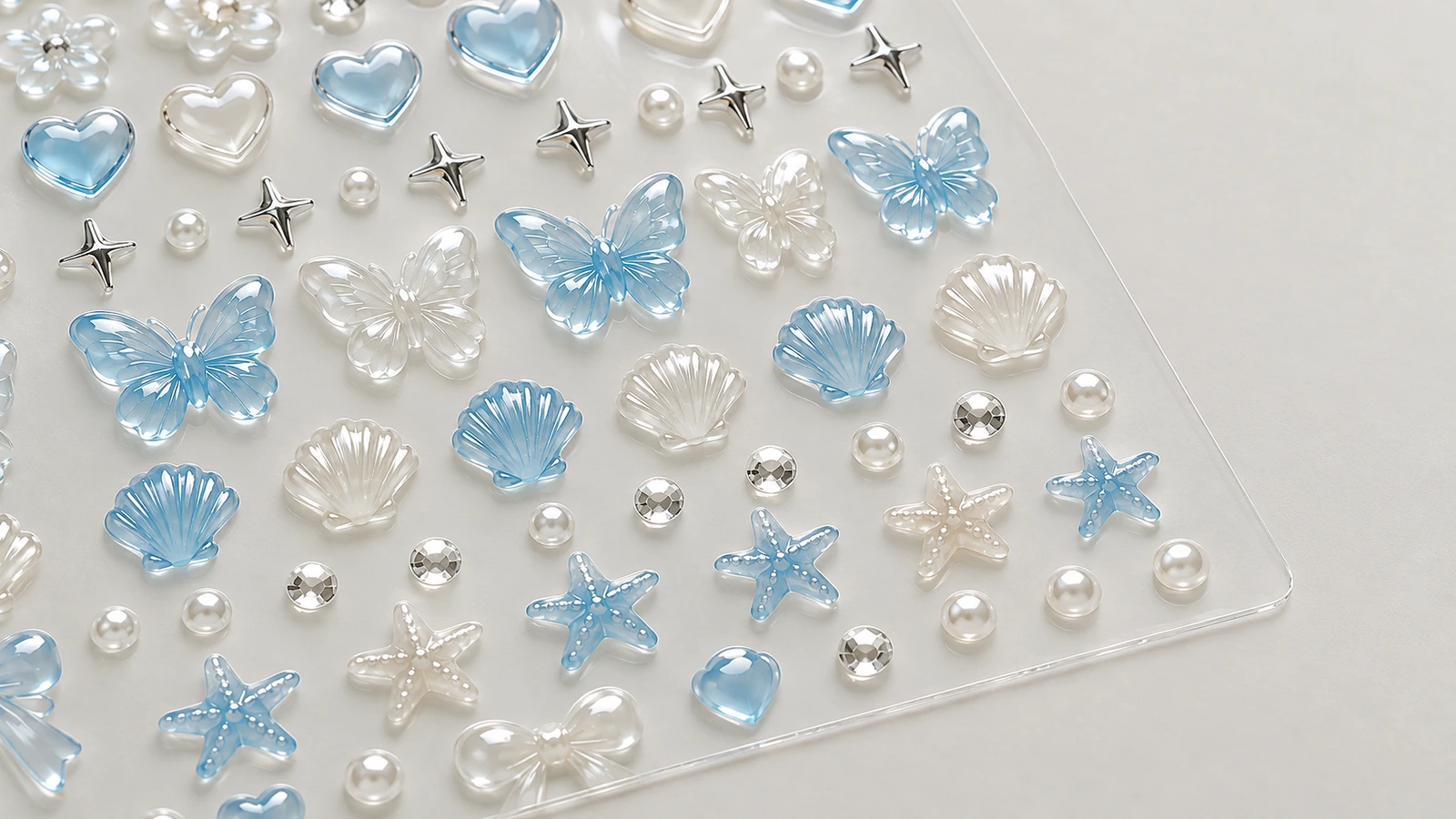 Primer plano de mariposas azules, conchas, corazones y decoraciones en relieve de color perla